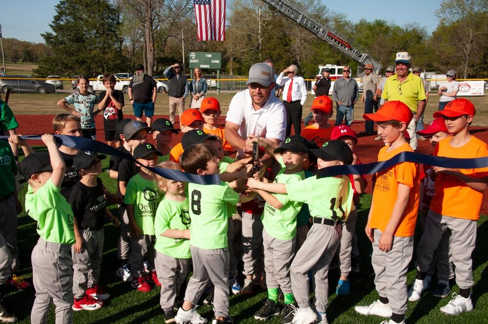 Parks Director cutting ribbon with young players.