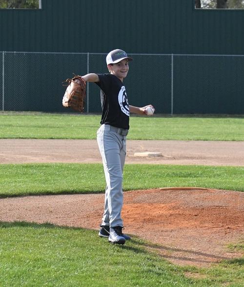 Young boy wearing a baseball glove throwing a baseball
