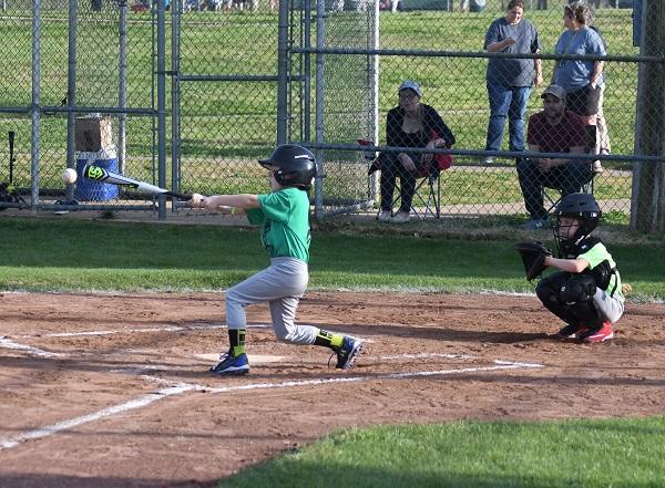 Child swinging the bat and a child playing catcher