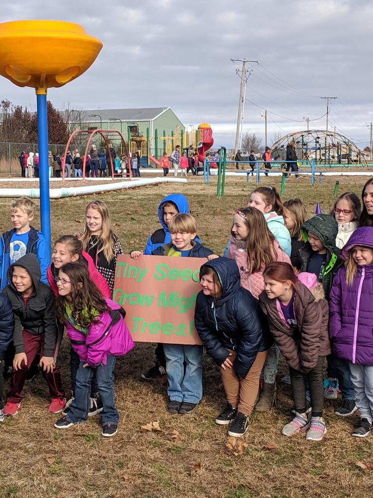 Group of children on playground holding a sign