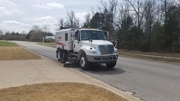 Sweeper truck cleaning curbline