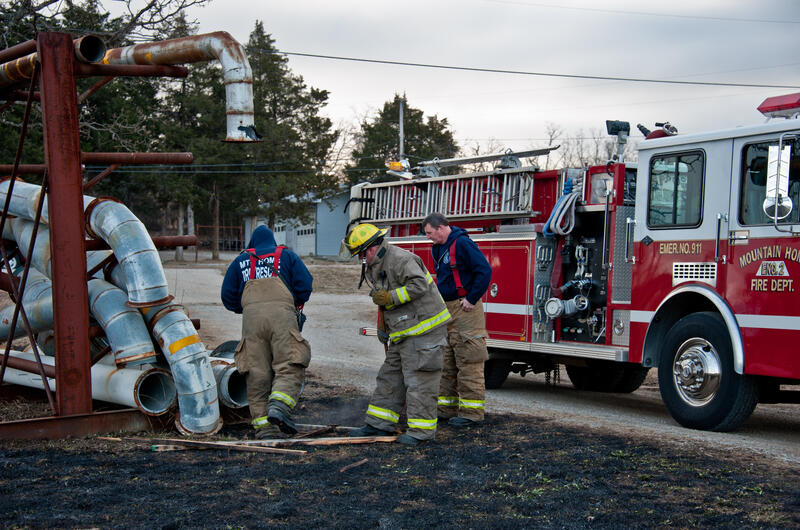 Three firemen with truck and piping