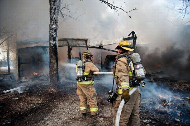 Firemen with hose putting out fire