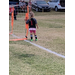 Youth soccer player with her arm around a goal post.