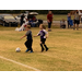 Two youth soccer opponents chasing after the ball.
