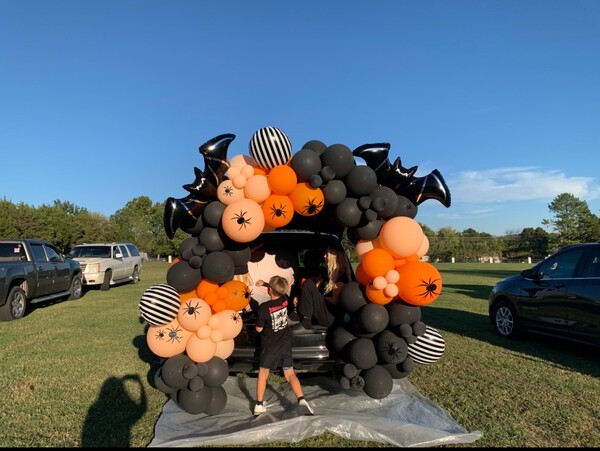 trunk or treat set up featuring orange and black balloons 